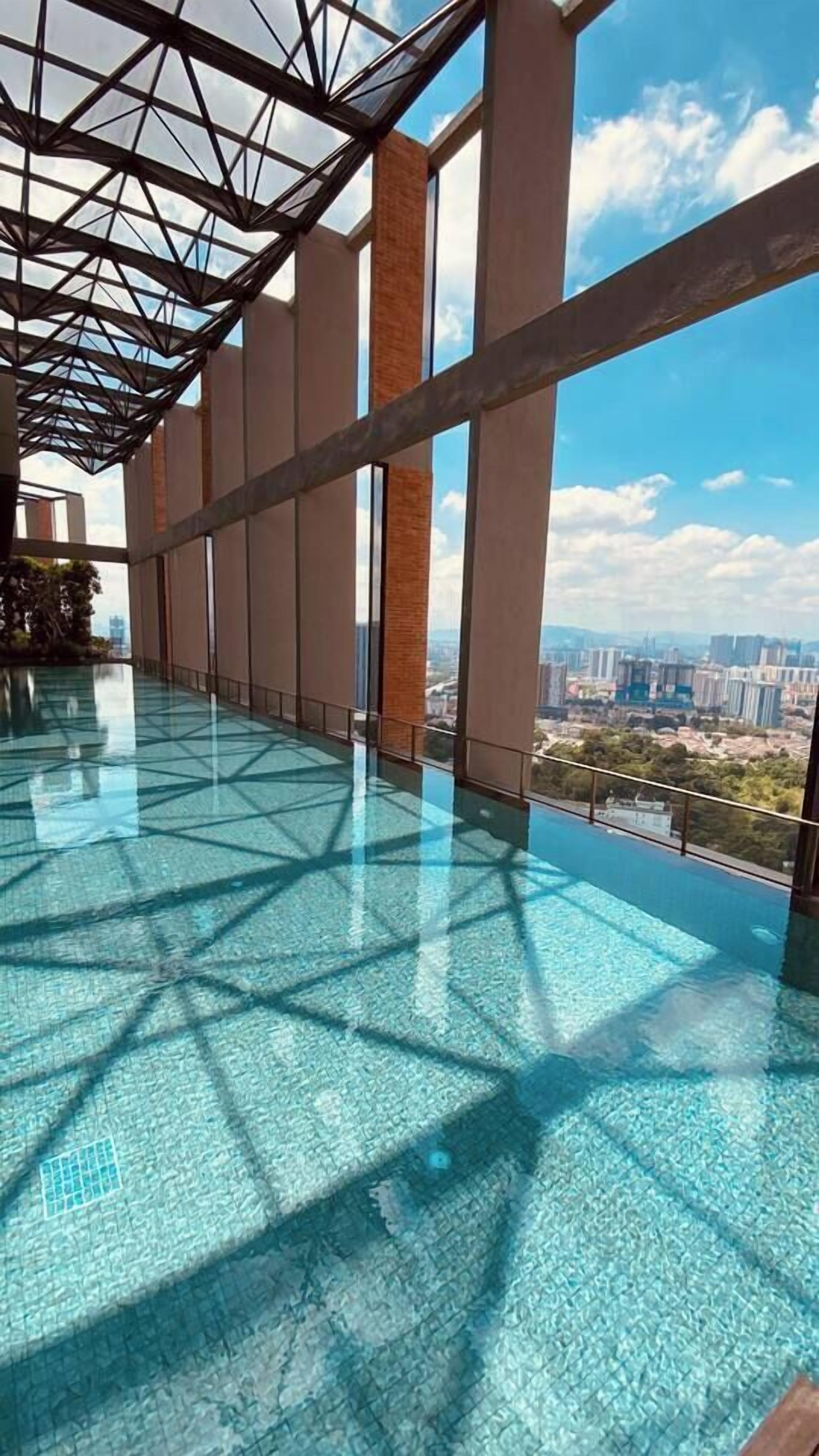 Una piscina infinita en la azotea con vistas despejadas al horizonte de la ciudad.