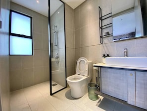 Un baño moderno con inodoro, ducha y lavamanos.