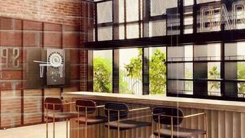 A modern bar area with a brick wall, large windows, and a tiled floor.
