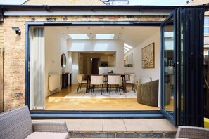 Ein modernes Interieur mit Essbereich, Küche und einer großen Glasschiebetür zu einem Außenbereich.