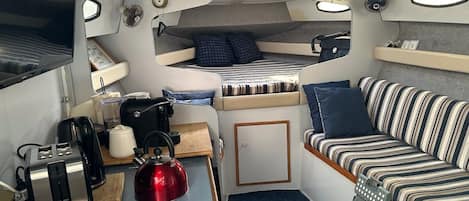 A compact kitchenette with a sink, a toaster, a kettle, and a small refrigerator.