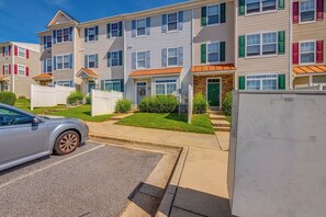 A multi-story residential building with a parking area in front.