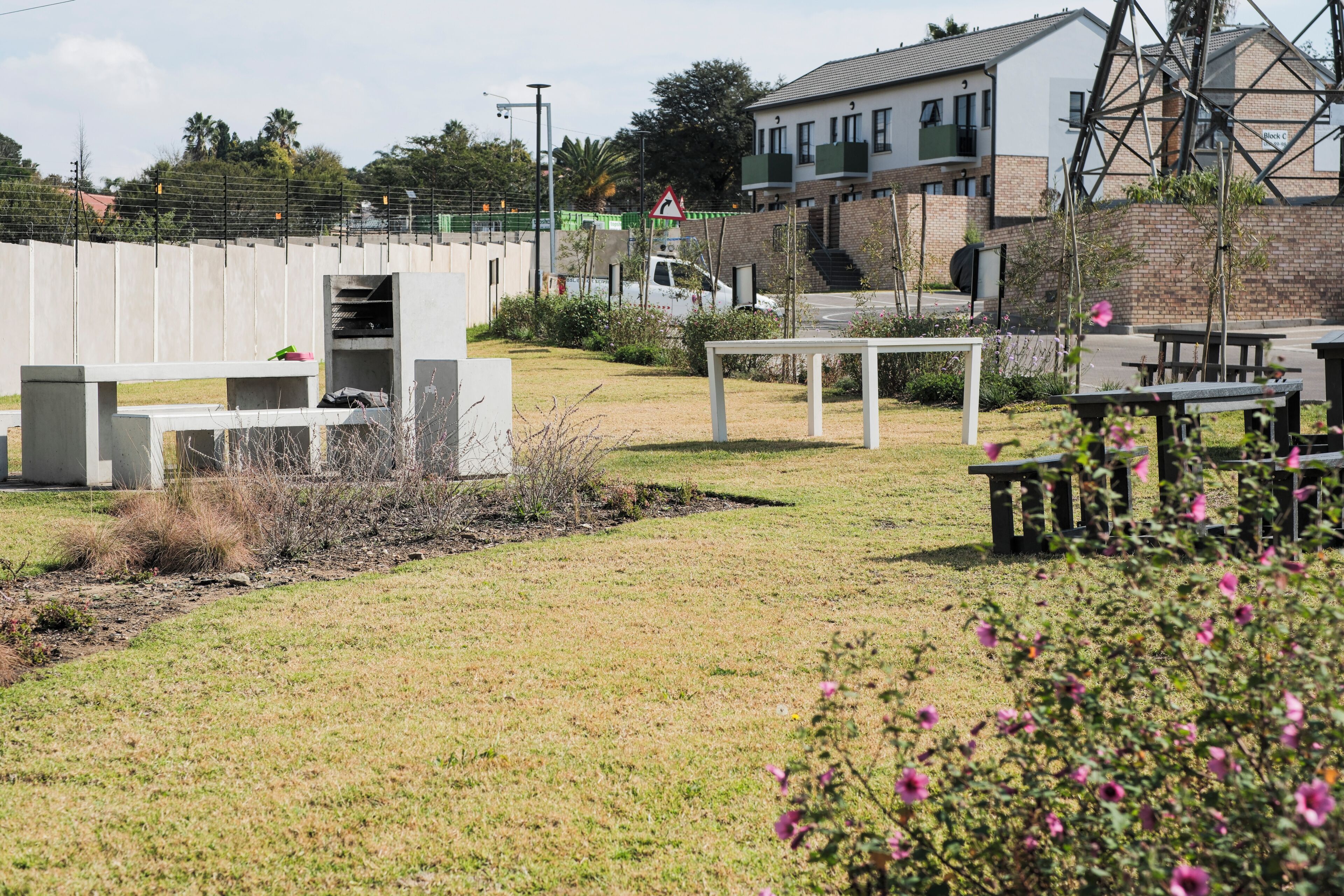 An outdoor area with a concrete structure, a white table, and a bench.