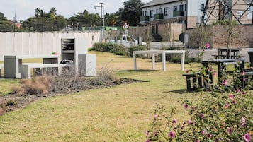 An outdoor area with a concrete structure, a white table, and a bench.