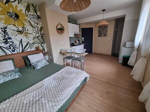 Ein Schlafzimmer mit einem Bett, einer kleinen Küchenzeile und einem Essbereich.