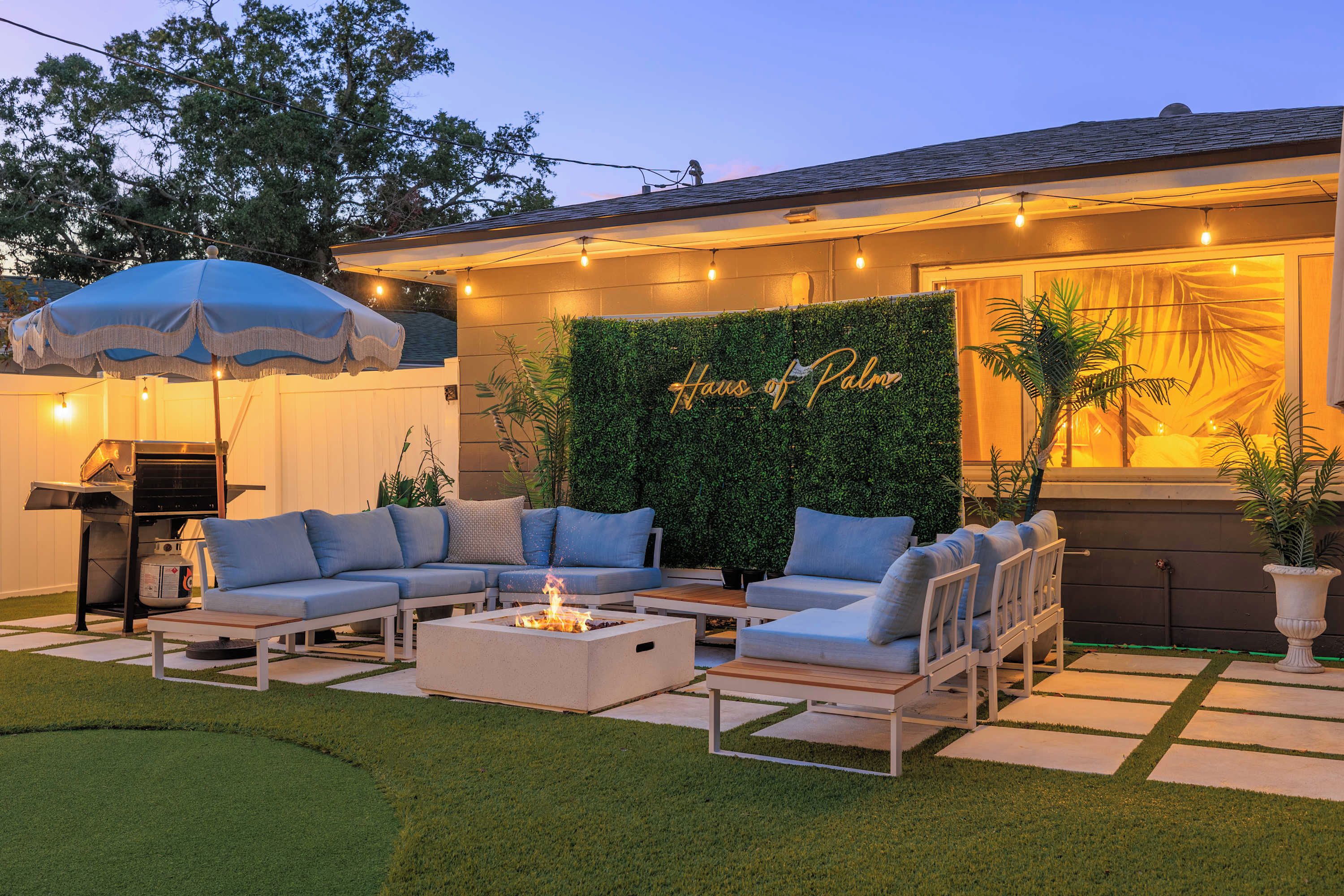 An outdoor patio area with a fire pit, seating, and a wall-mounted sign.
