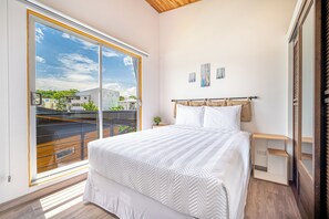 A bedroom with a large window, a bed with white bedding, a bedside table, and a nightstand. - Luxurious 6-Unit Oasis < 1 Mi to Playas Del Coco! (Playas del Coco)