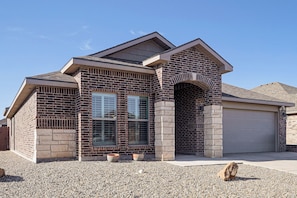 A two-story house with a brick facade, a garage, and a gravel driveway. - Grill & Yard! Family Escape, 8 Mi to Dtwn Odessa (Odessa)