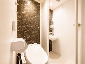 A modern bathroom with a toilet, a sink, and a shower area. - Sky Link Hotel Tokyo (Sumida-ku, Oshiage)