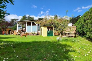 A residential property with a house, a small shed, and a fenced garden area. - Holiday apartment with 1 bedroom (Kölpinsee \/ Loddin)
