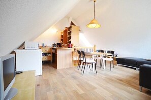 A compact living space with a dining area, kitchenette, and a television. - Holiday apartment with 1 bedroom (Kölpinsee \/ Loddin)