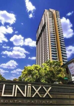 Ein hohes Gebäude mit einem Schild, auf dem 'UNIX South Pattaya' steht.