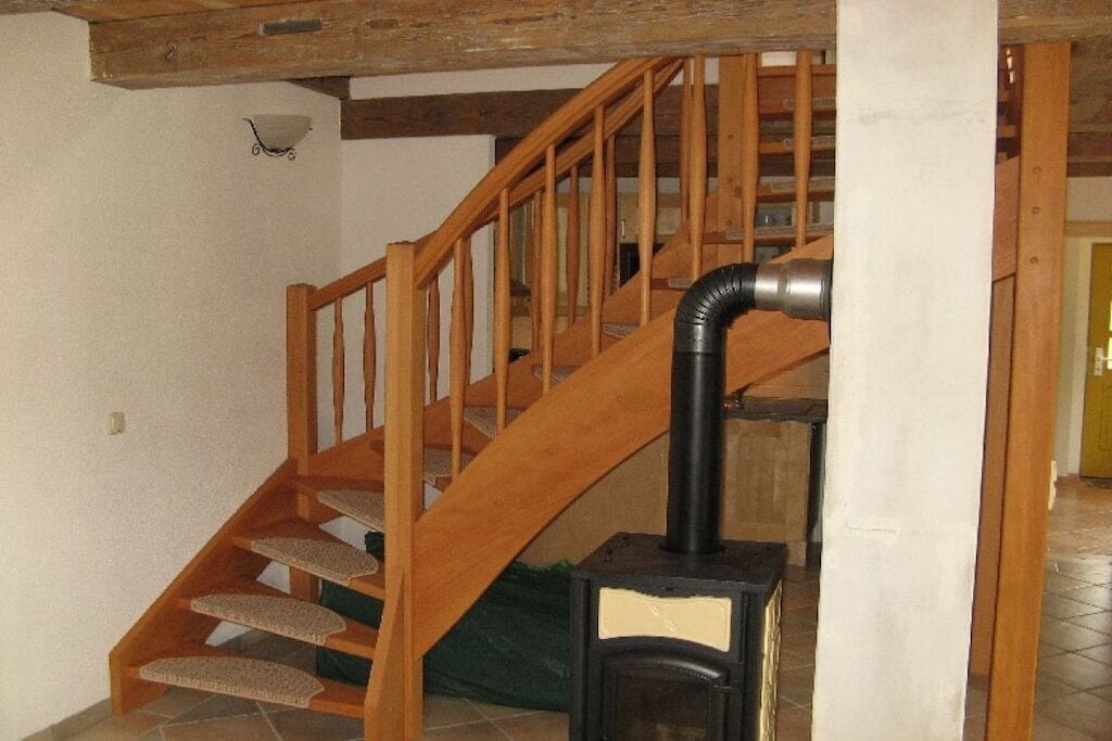 A wooden staircase with a black heater at the bottom.