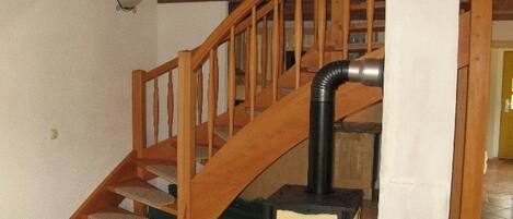 A wooden staircase with a black heater at the bottom.
