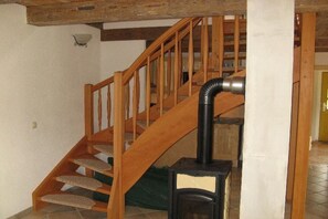 Eine Holztreppe mit einer schwarzen Heizung unten.