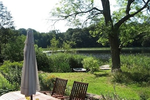 An outdoor seating area with a table, chairs, and an umbrella. - Seeidyll Comthurey - Willow House (Wokuhl-Dabelow OT Comthurey)