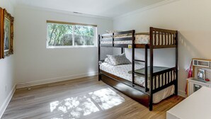 A room with a bunk bed, a window with a view of trees, and a small kitchenette area. - 1 Mi to Courthouse Plaza! Home w/ Deck + Fireplace (Prescott)