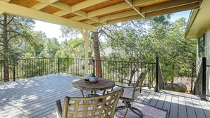A covered outdoor deck with a round table and chairs, surrounded by a wooden railing. - 1 Mi to Courthouse Plaza! Home w/ Deck + Fireplace (Prescott)