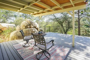 An outdoor patio with a wooden deck, two chairs, a small table, and a decorative bird feeder. - 1 Mi to Courthouse Plaza! Home w/ Deck + Fireplace (Prescott)