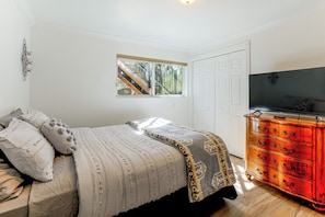 A bedroom with a bed, a dresser, a television, and a window with a view of a staircase. - 1 Mi to Courthouse Plaza! Home w/ Deck + Fireplace (Prescott)