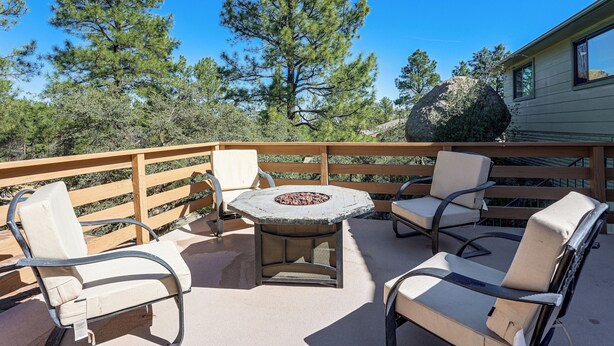 A patio with outdoor seating, a fire pit, and a view of surrounding trees and a house. - 1 Mi to Courthouse Plaza! Home w/ Deck + Fireplace (Prescott)