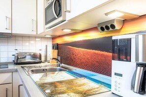A modern kitchen with a toaster, a microwave, and a coffee maker. - Apartment in Juist with swimming pool (Juist)