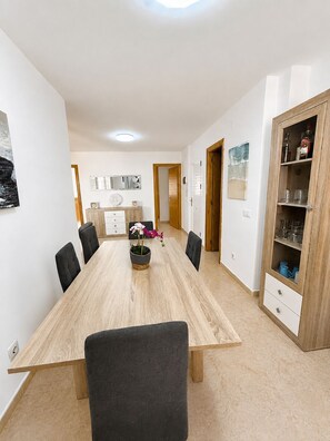 A spacious dining area with a long wooden table, black chairs, and a potted orchid. - residencial portofino VI oropesa ref 081 (Oropesa del Mar)