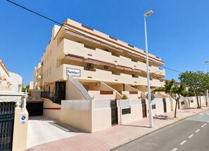 A multi-story building with a sign indicating 'Portofino V' and a gated entrance. - residencial portofino VI oropesa ref 081 (Oropesa del Mar)