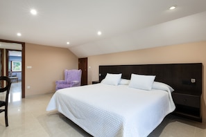 A bedroom with a large bed, a chair, and a nightstand.