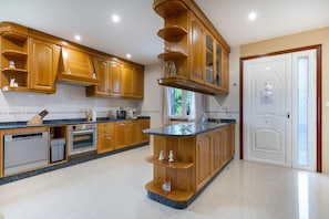 A kitchen with wooden cabinets, a built-in oven, and a granite countertop.