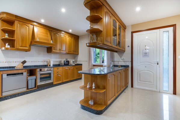 A kitchen with wooden cabinets, a built-in oven, and a granite countertop.