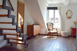 A room with a modern staircase, a wooden cabinet, a chair, a radiator, and a window with curtains. - Rooftop terrace loft apartment, home cinema (Praha 10)