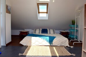A bedroom with a bed, a window, a small table, a shelf, and a plant. - Rooftop terrace loft apartment, home cinema (Praha 10)