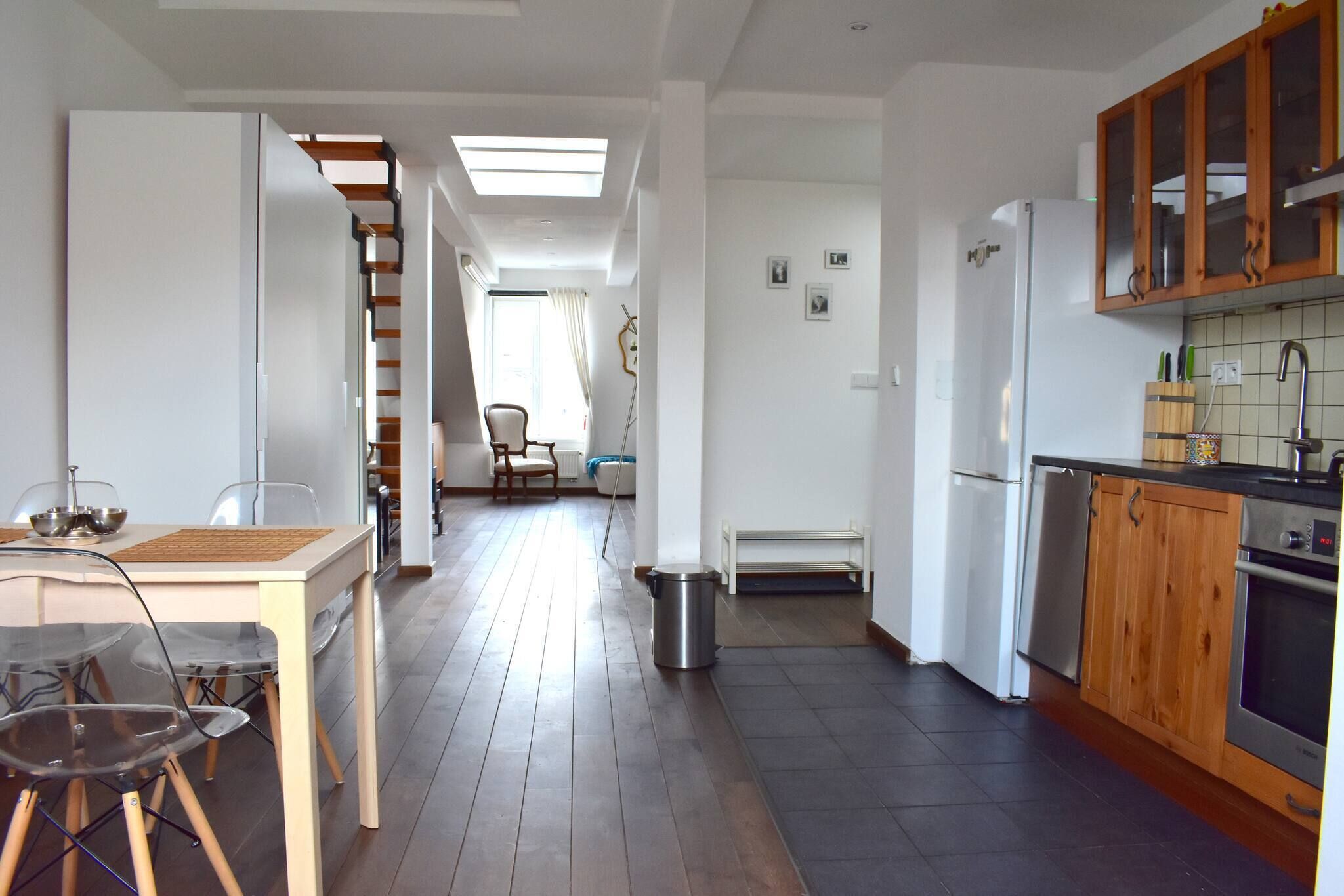 A modern kitchen with wooden cabinets, a refrigerator, and a stove.
