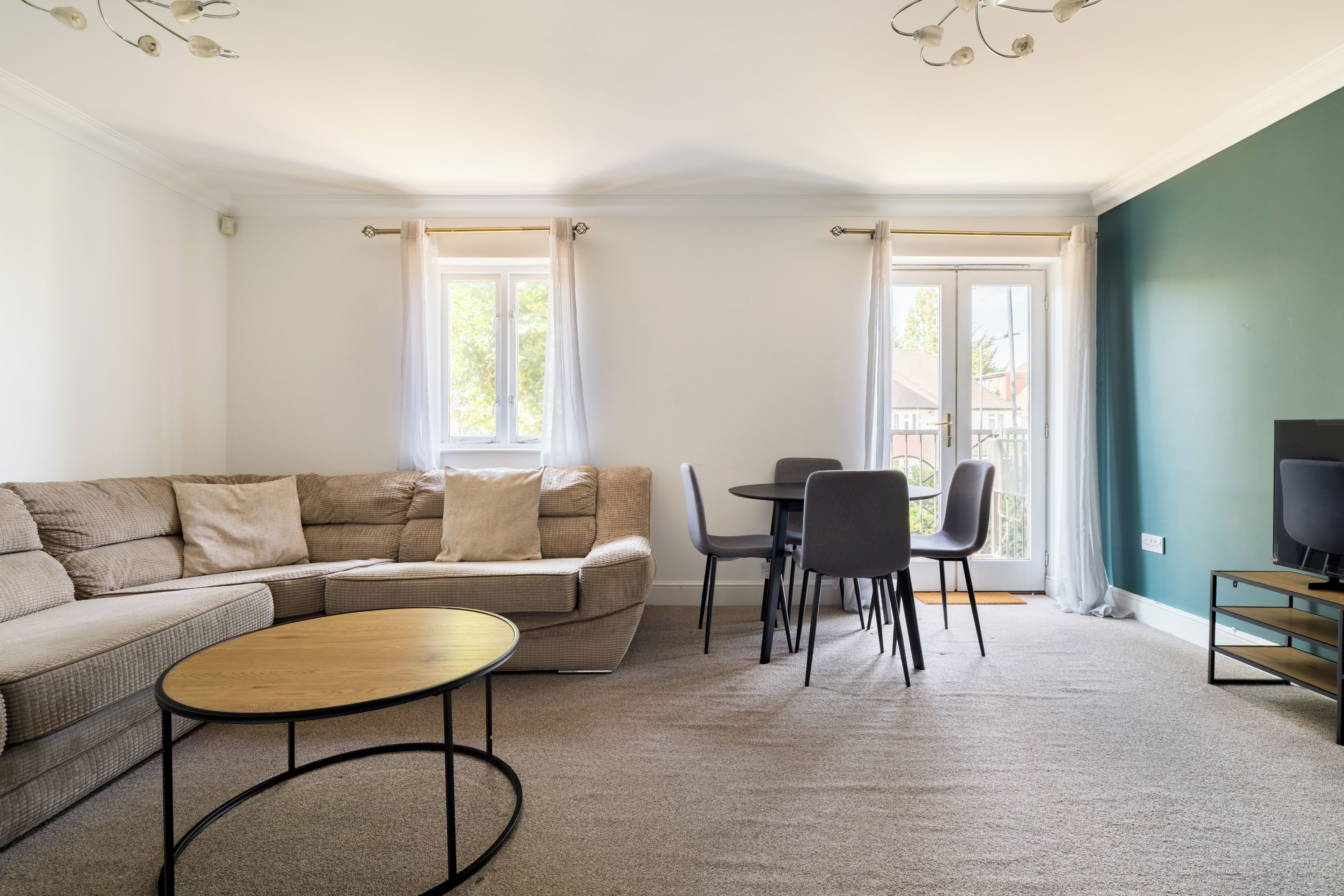 Un salon comprenant un canapé, une table basse ronde et un coin repas avec des chaises et une table.