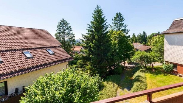 Bairro residencial com casas, céu claro e gramado bem cuidado.