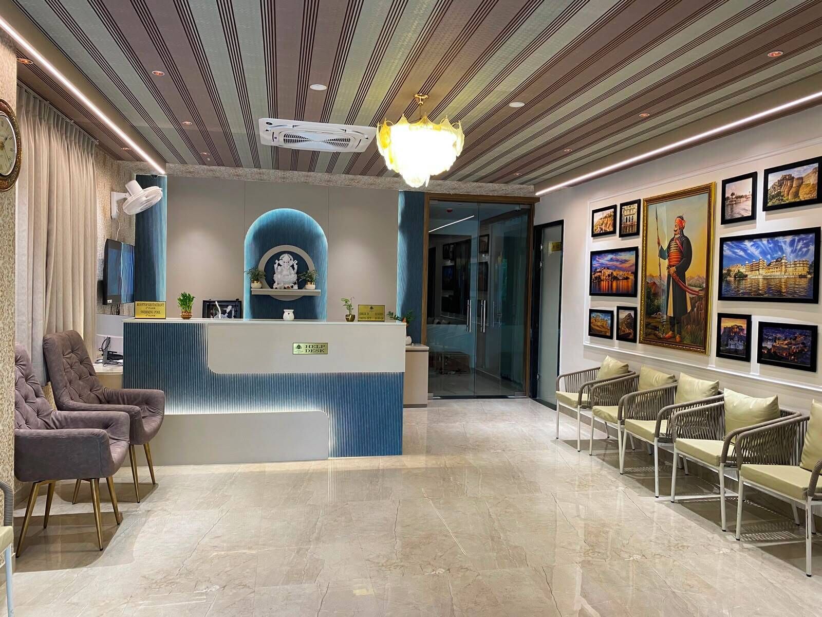 Un espace d’accueil d’hôtel comprenant un bureau d’information, des sièges et un mur décoré de tableaux encadrés.