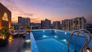 Ein Dachpool mit Blick auf umliegende Gebäude in der Abenddämmerung.