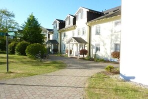 Une rue résidentielle bordée de maisons, avec une allée pavée et un vélo.