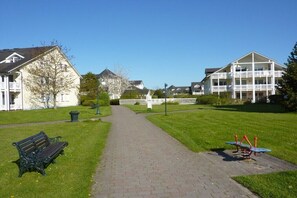 A pathway leading to a building with a white facade and multiple windows. - Holiday apartment with 1 bedroom (Ostseebad Binz)