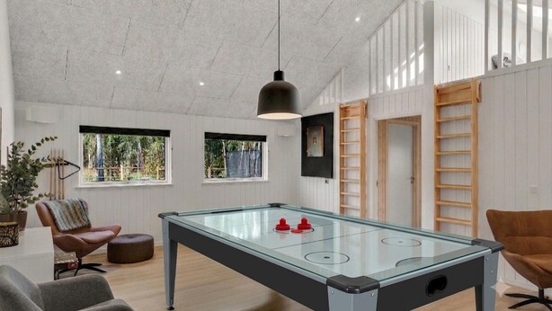 A modern room with a foosball table, a comfortable seating area, and large windows providing natural light. - VillaVilla 972 - Ålbæk, Nordjylland (Ålbæk)