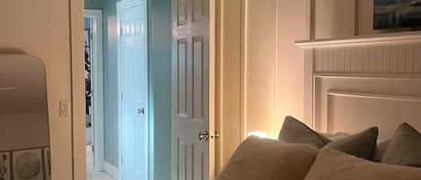 A bedroom with a bed, a fireplace, and a door leading to another room.
