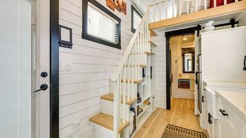A staircase with white railings and wooden steps leading to a second floor.