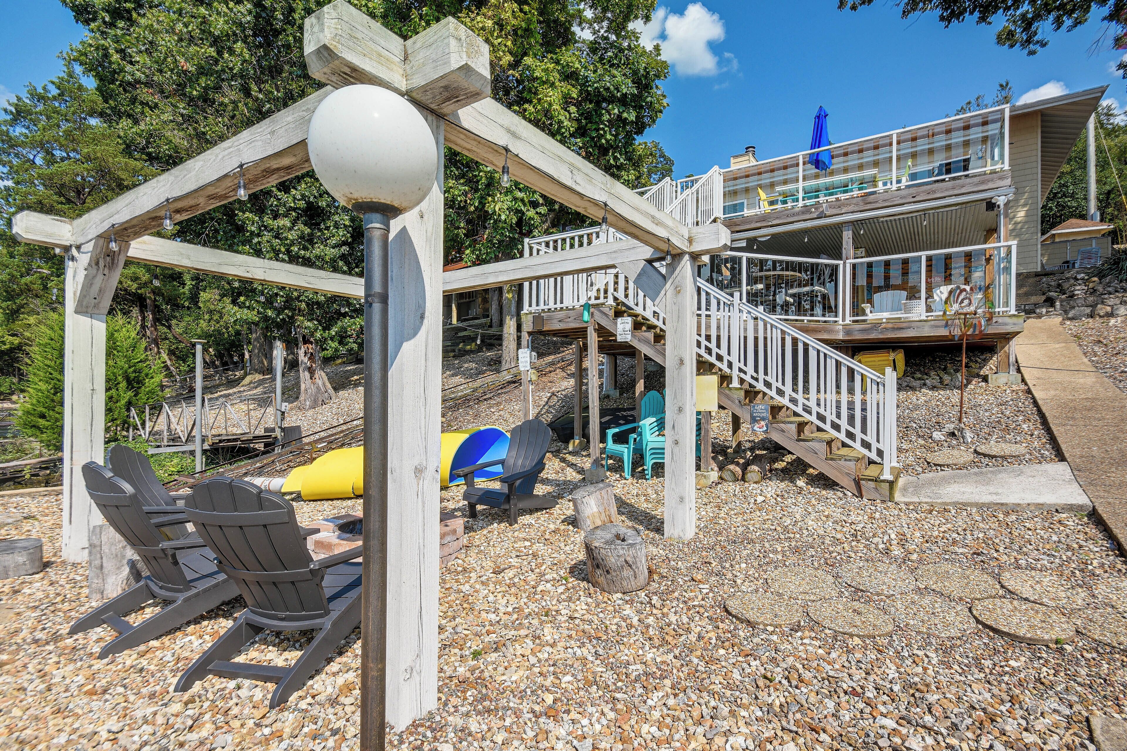 A wooden deck with a gazebo, outdoor seating, and a staircase leading to a building.