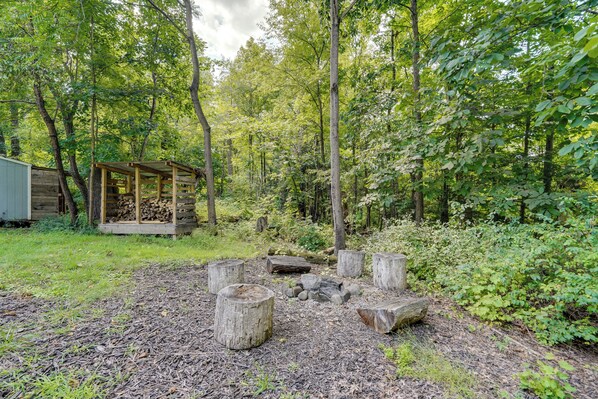 A rustic wooden cabin with a covered porch in a forested area.