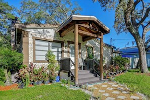 A two-story house with a stone facade, a wooden porch, and a garden with potted plants. - Private Patio & Grill! Tampa Studio Retreat (Tampa)