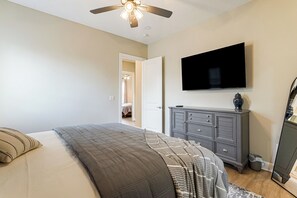 A bedroom with a bed, a dresser, a television, and a ceiling fan. - Golf, Grill & Relax! Brand-New Augusta Retreat (Augusta)