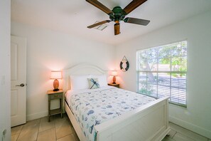 A bedroom with a bed, two bedside lamps, a ceiling fan, a window with blinds, and a door. - 3 Mins to Beach! Poolside Paradise in Siesta Key (Siesta Key)