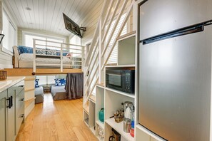 Eine kleine Küche mit einer Mikrowelle, einem Kühlschrank und Holzschränken.