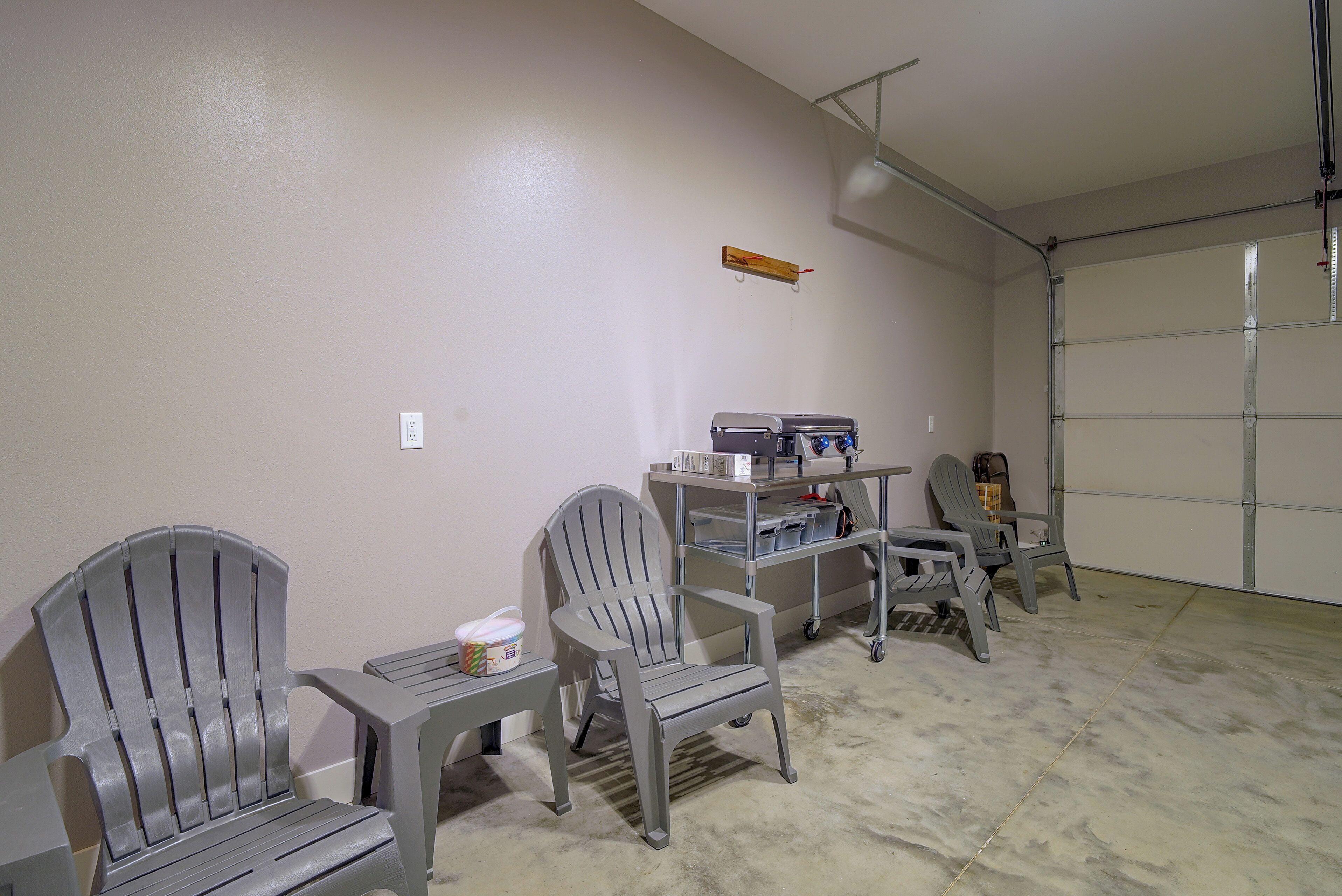 Un garage équipé d’un établi, de chaises et d’une prise de courant au mur.